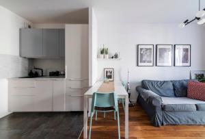 a kitchen and living room with a table and a couch at Apartament doris doris in Poznań