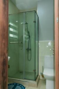 a glass shower in a bathroom with a toilet at Picturesque 3-bedroom Apartment in Yaba in Lagos