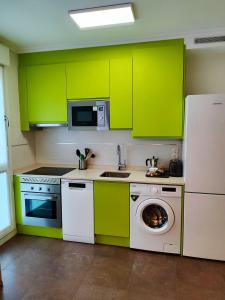 eine Küche mit grünen Schränken und einer Waschmaschine in der Unterkunft Los Caños de Rivero, con GARAJE y WIFI, VUT-4366-AS in Avilés