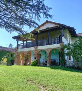 une maison avec un balcon au-dessus d'une cour dans l'établissement Casa delle foglie sussurranti, à Asti