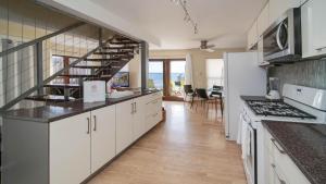 uma cozinha com armários brancos e uma escada em Seven Mile View Condo #4 em West Bay