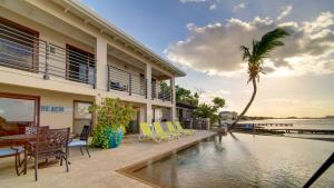 a house with a swimming pool and a palm tree at Seven Mile View Condo #4 in West Bay
