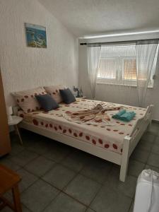 a large white bed in a room with a window at Apartment Denisse in Rogoznica