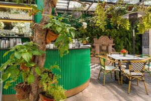 a table and chairs in a garden with plants at Orchid House Polanco in Mexico City