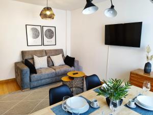 ein Wohnzimmer mit einem Sofa und einem Tisch in der Unterkunft Los Caños de Rivero, con GARAJE y WIFI, VUT-4366-AS in Avilés