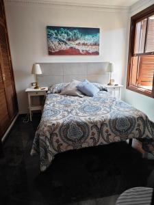 ein Schlafzimmer mit einem Bett und zwei Tischen mit Lampen in der Unterkunft Villa compartida Gonzalez in Radazul