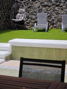 zwei Stühle in einem Garten mit Gras in der Unterkunft Villa compartida Gonzalez in Radazul