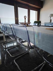 a glass table and chairs with a view of the ocean at Villa compartida Gonzalez in Radazul