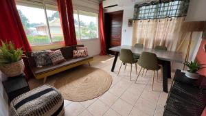 een woonkamer met een tafel en stoelen bij F2 rénové, climatisé et lumineux in Cayenne