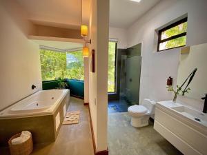 een badkamer met een bad, een toilet en een wastafel bij Satori Home In San Lucas in Medellín