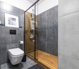 a bathroom with a toilet and a glass shower at Apartament doris doris in Poznań