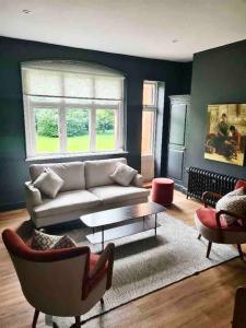 a living room with a couch and a table at The Old Vicarage - sleeps 20 in Kettleburgh