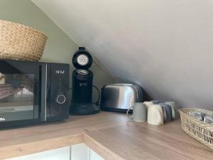 a kitchen counter with a microwave and a clock at La Bellevue x Parking by Melrose in Bayeux