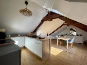 a kitchen with a table and a dining room at La Bellevue x Parking by Melrose in Bayeux