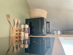 a kitchen with a counter with utensils and a microwave at La Bellevue x Parking by Melrose in Bayeux