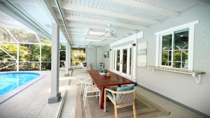 a dining room with a table and chairs and a pool at Luxury Jupiter Farm Getaway Pool, BBQ, Game Shed in Jupiter