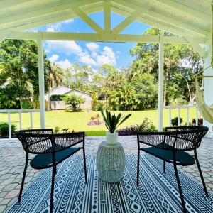 two chairs and a table with a vase on a patio at Luxury Jupiter Farm Getaway Pool, BBQ, Game Shed in Jupiter
