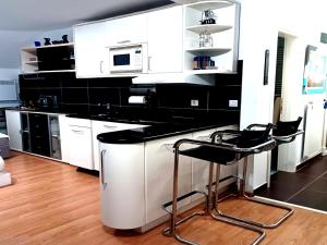 a kitchen with white cabinets and a black counter top at Desperado in Slavonski Brod
