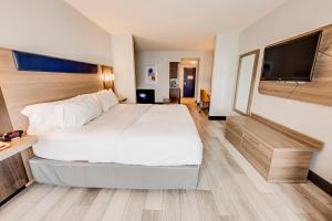 a hotel room with a large bed and a flat screen tv at Holiday Inn Express Hotel & Suites Ohio State University- OSU Medical Center, an IHG Hotel in Columbus