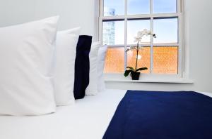 - une chambre avec un lit doté d'oreillers blancs et d'une fenêtre dans l'établissement Modern Studio in Historic Boston - Unit #401, à Boston