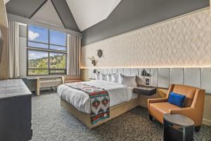 Habitación de hotel con cama, silla y ventana en MTN House By Basecamp, en Canmore