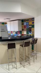 una cocina con 2 sillas y una barra con azulejos en Apt por temporada - Ponta Verde - De frente ao Caminho de Moises - 02 quartos, en Maceió