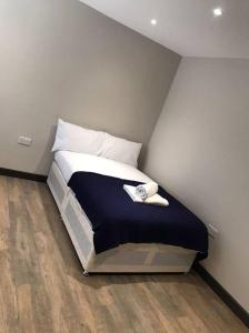 a bed in a corner of a room at Bedfont House in New Bedfont