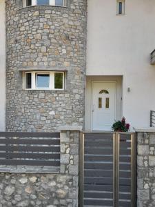 a stone building with a gate and a white door at chloi house in Kastoria