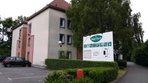 un bâtiment avec un panneau en face d'un parking dans l'établissement Mister Bed Lomme, à Lomme