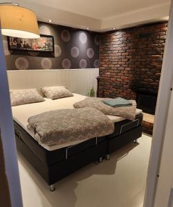 a bedroom with two beds and a brick wall at Aparthouse OSLO in Oslo