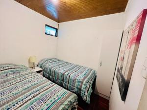 1 dormitorio con 2 camas y TV en la pared en Casa y departamentos amoblados Talca, en Talca