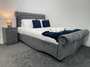 a bedroom with a large bed with blue and white pillows at Redcar Retreat in Redcar