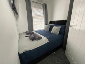 a bedroom with a bed with blue sheets and pillows at Redcar Retreat in Redcar