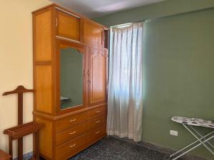 a bedroom with a wooden cabinet and a window at DEPAVICE in Piura