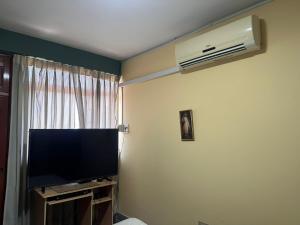a living room with a television and a air conditioner at DEPAVICE in Piura
