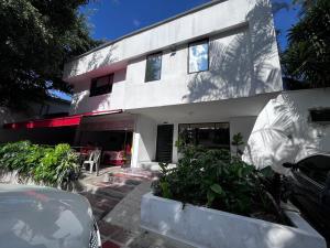une maison blanche avec une voiture garée devant elle dans l'établissement Hotel la Carpita, à El Poblado