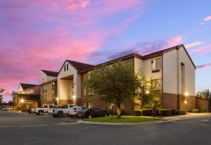 a hotel with cars parked in a parking lot at Red Roof Inn & Suites Savannah Airport in Savannah