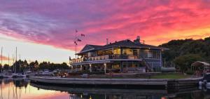 a house on a boat in the water with a sunset at Basement Apartment in Luxury Beach House in Toronto