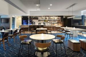 a restaurant with tables and chairs and a bar at Courtyard by Marriott West Palm Beach in West Palm Beach