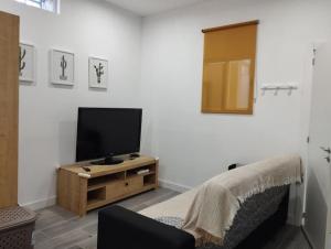 a living room with a flat screen tv on a wooden cabinet at Apartamento Carol in Reus