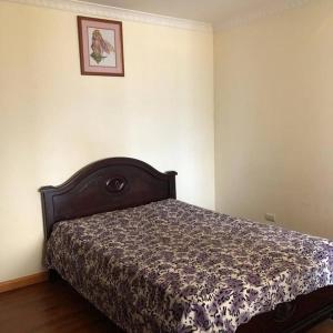 ein Bett in einem Schlafzimmer mit einem Bild an der Wand in der Unterkunft Departamento acogedor y moderno, vista increíble. in Loja