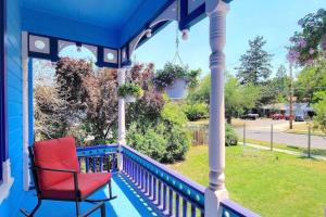 una silla roja sentada en un porche azul en Barclay Klum House by WanderLodges, en Ashland