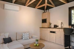 a living room with a white couch and a kitchen at Berthina House in Dhrakopouláta