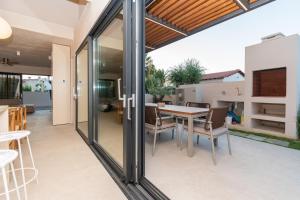 a glass extension of a house with a table and chairs at SithoniaRS Luxury Three Floors Villa With Private Pool & Garden in Nikiti