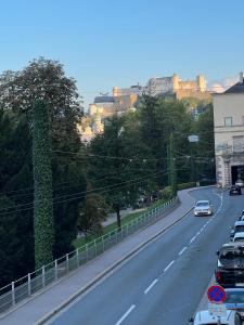 eine Straße mit Autos, die an einer Straße geparkt sind in der Unterkunft Palais am Kai - Zentrale Lage, Kostenloser Parkplatz in Salzburg