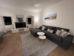 a living room with a couch and a table at Palais am Kai - Zentrale Lage, Kostenloser Parkplatz in Salzburg