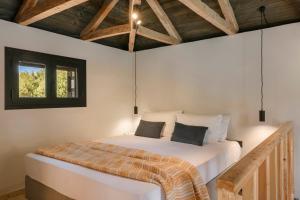 a bedroom with a bed in a room with wooden ceilings at Berthina House in Dhrakopouláta