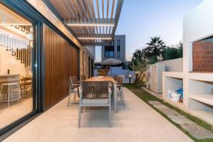 an outdoor dining area with a table and chairs at SithoniaRS Luxury Three Floors Villa With Private Pool & Garden in Nikiti