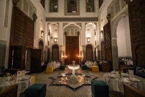 una grande stanza con tavoli e sedie in un edificio di Riad Fes Ziyat & Spa a Fes