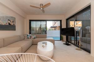 a living room with a couch and a flat screen tv at SithoniaRS Luxury Three Floors Villa With Private Pool & Garden in Nikiti
